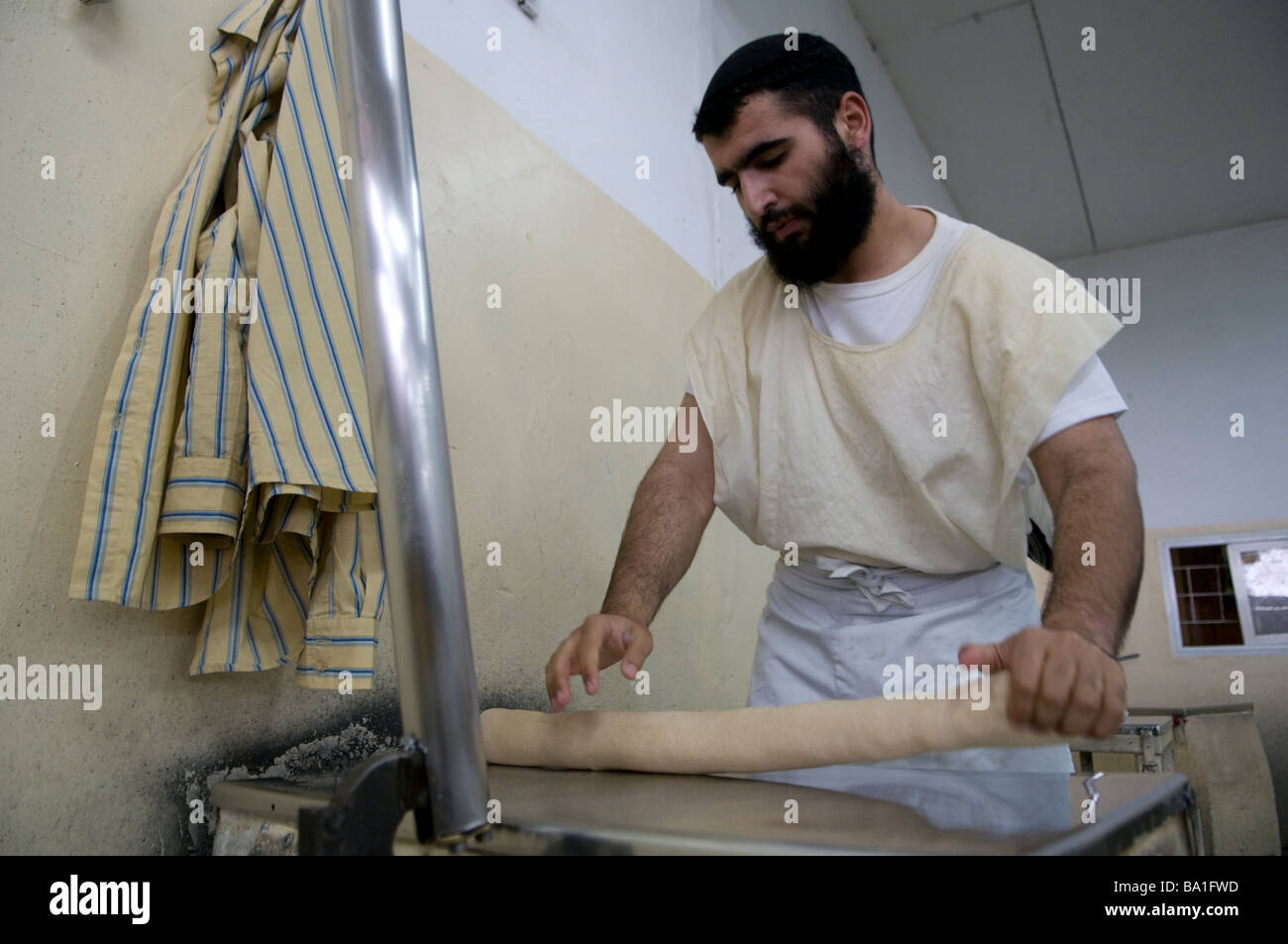 Ein religiöser Jude, der Matzot traditionelles ungesäuertes Brot zubereitete, das auf gegessen wurde Passah in der Kfar Chabad Bäckerei in Zentralisraelisch Stockfoto