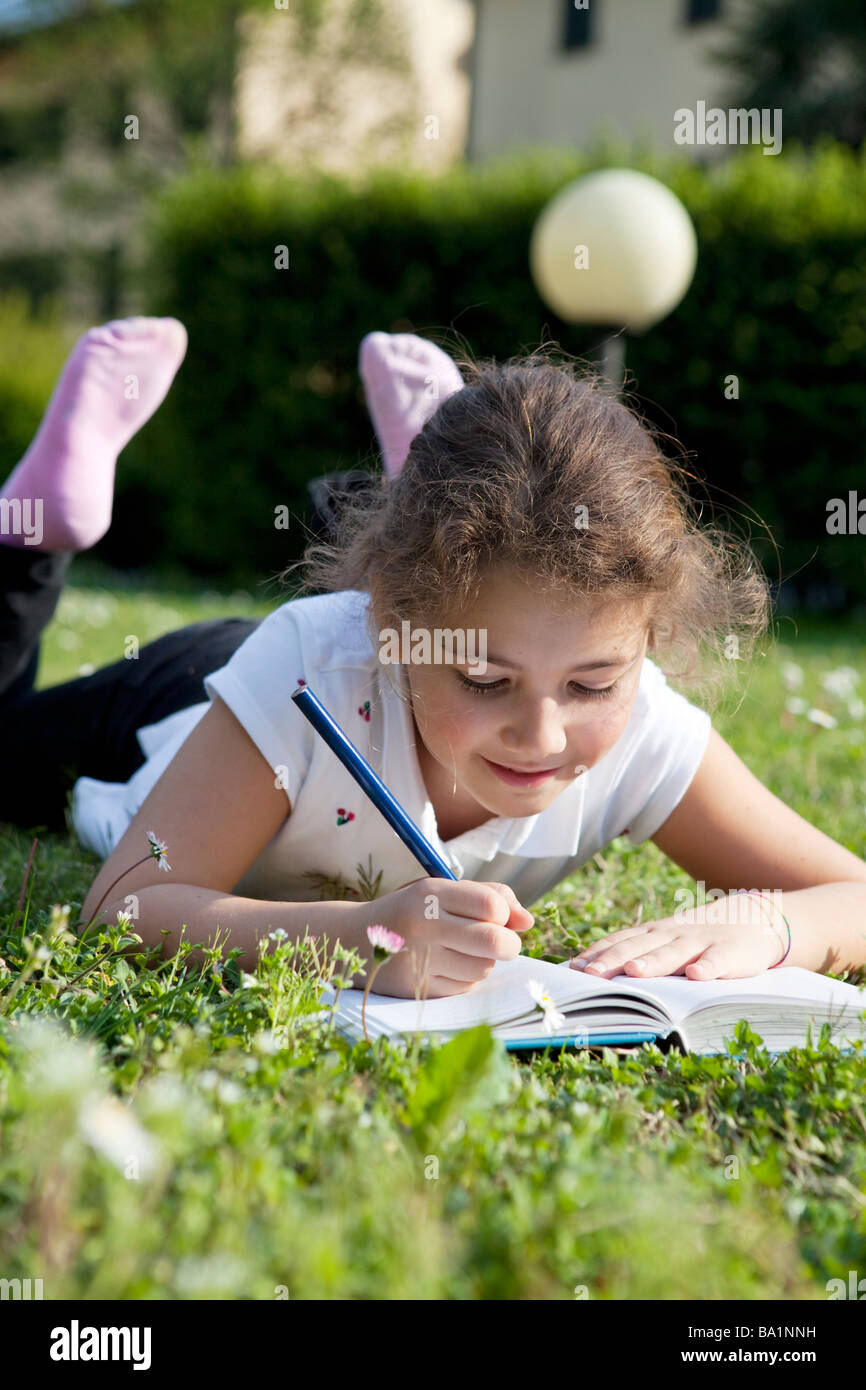 Kind im Gras Hausaufgaben Stockfoto