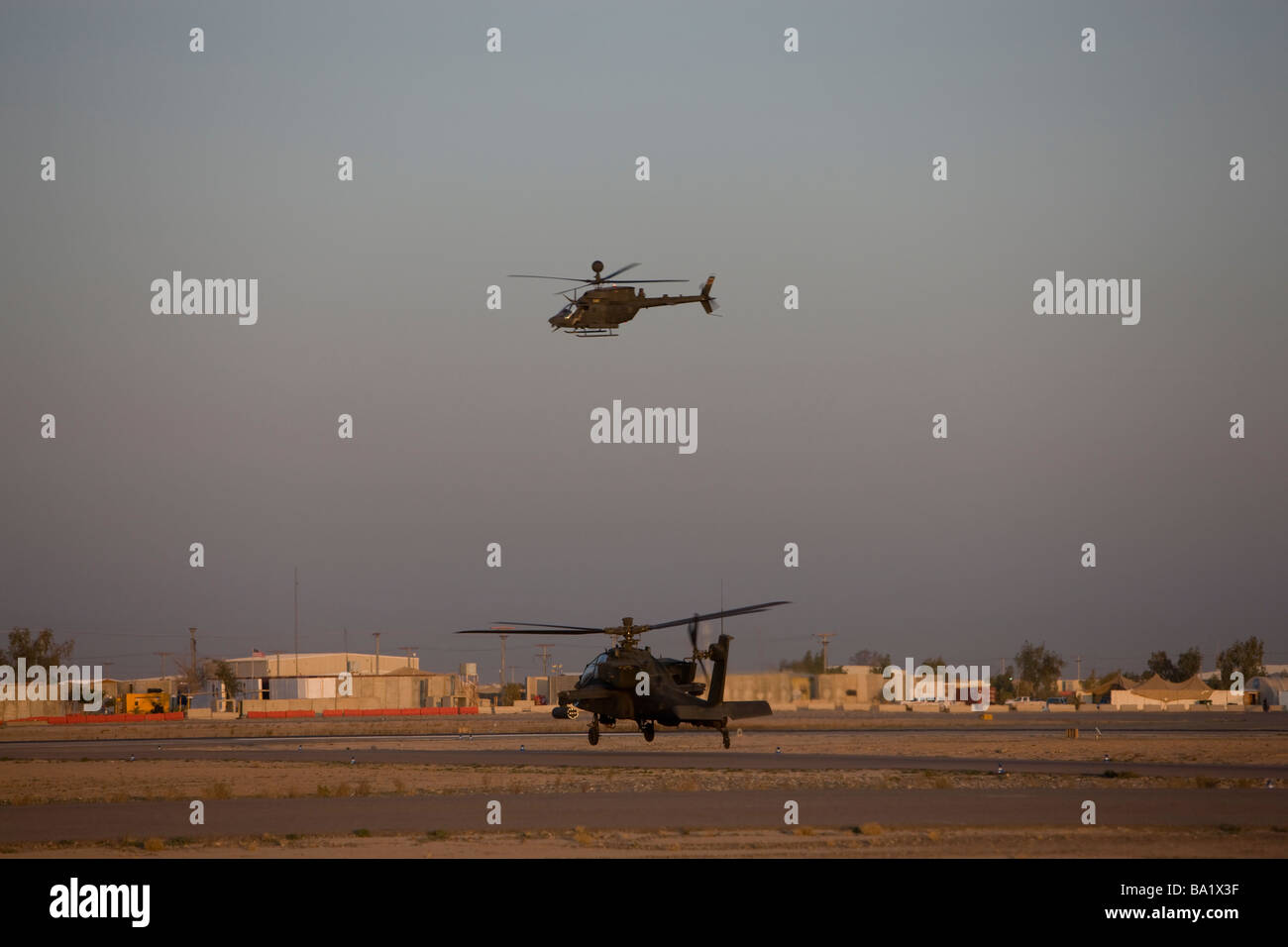 Tikrit, Irak - ein AH-64 Apache Hubschrauber wartet ein OH-58 Kiowa zu seinem Flug Platz zu schaffen. Stockfoto