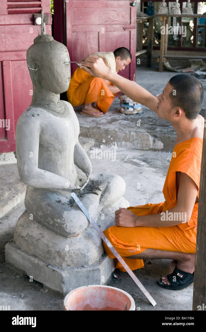 LAOS. Mönche, die BUDDHA-Statuen in einem WORKSHOP IN einem Kloster IN der Heiligen Stadt LUANG PRABANG machen Foto Julio Etchart Stockfoto
