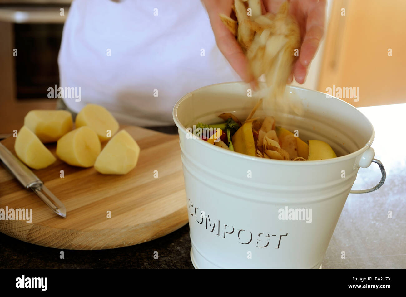 Frau weglegen Kartoffelschalen in Kompost Stockfoto