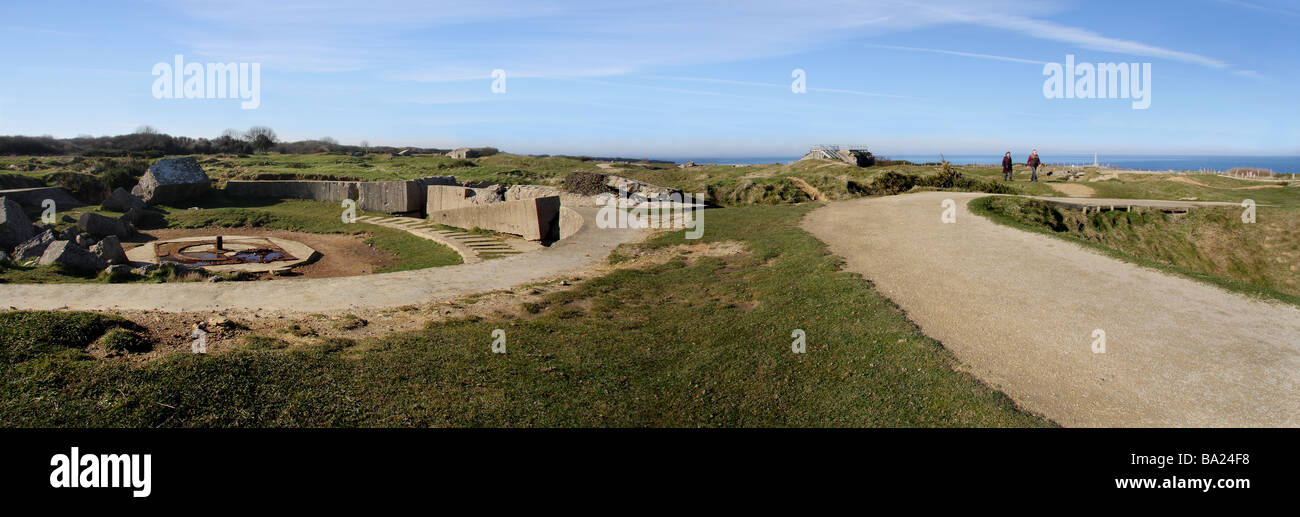 Einen Panoramablick auf die Point du Hoc-Website in der Normandie. Zwei Menschen zu Fuß auf den Weg. Pistole-Einlagerung in den Vordergrund. Stockfoto