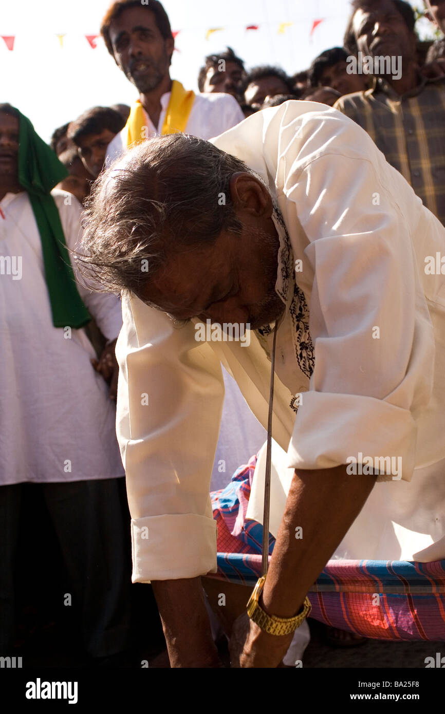 Ein Fakir spießt sich mit einem scharfen Eisenstange während einer Zeremonie zu Ehren des Speichers des Tipu Sultans in Mysore, Indien. Stockfoto