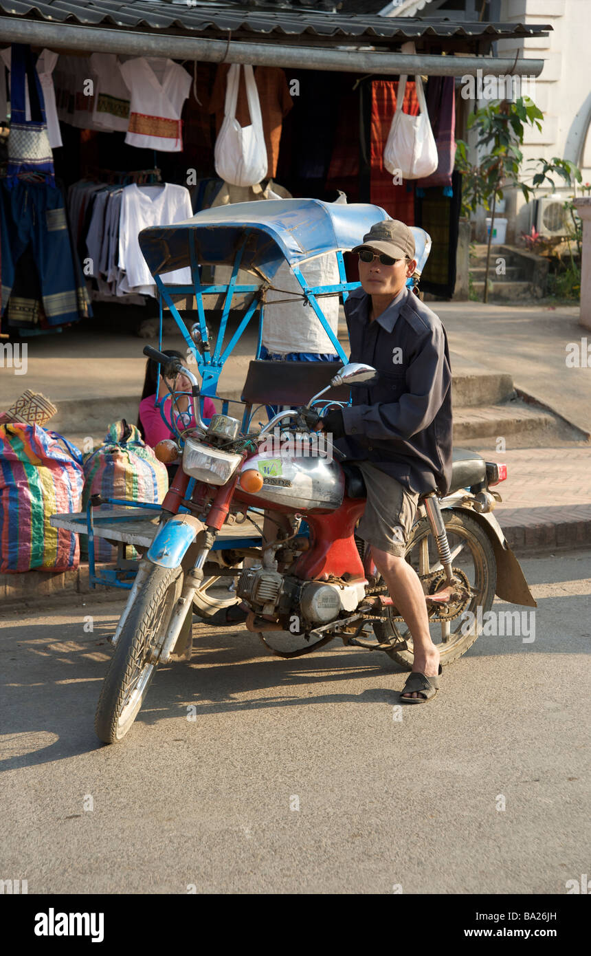Motorrad Tuk Tuk Fahrer warten auf eine Fahrkarte in der Nacht Markt von Luang Prabang Laos Stockfoto