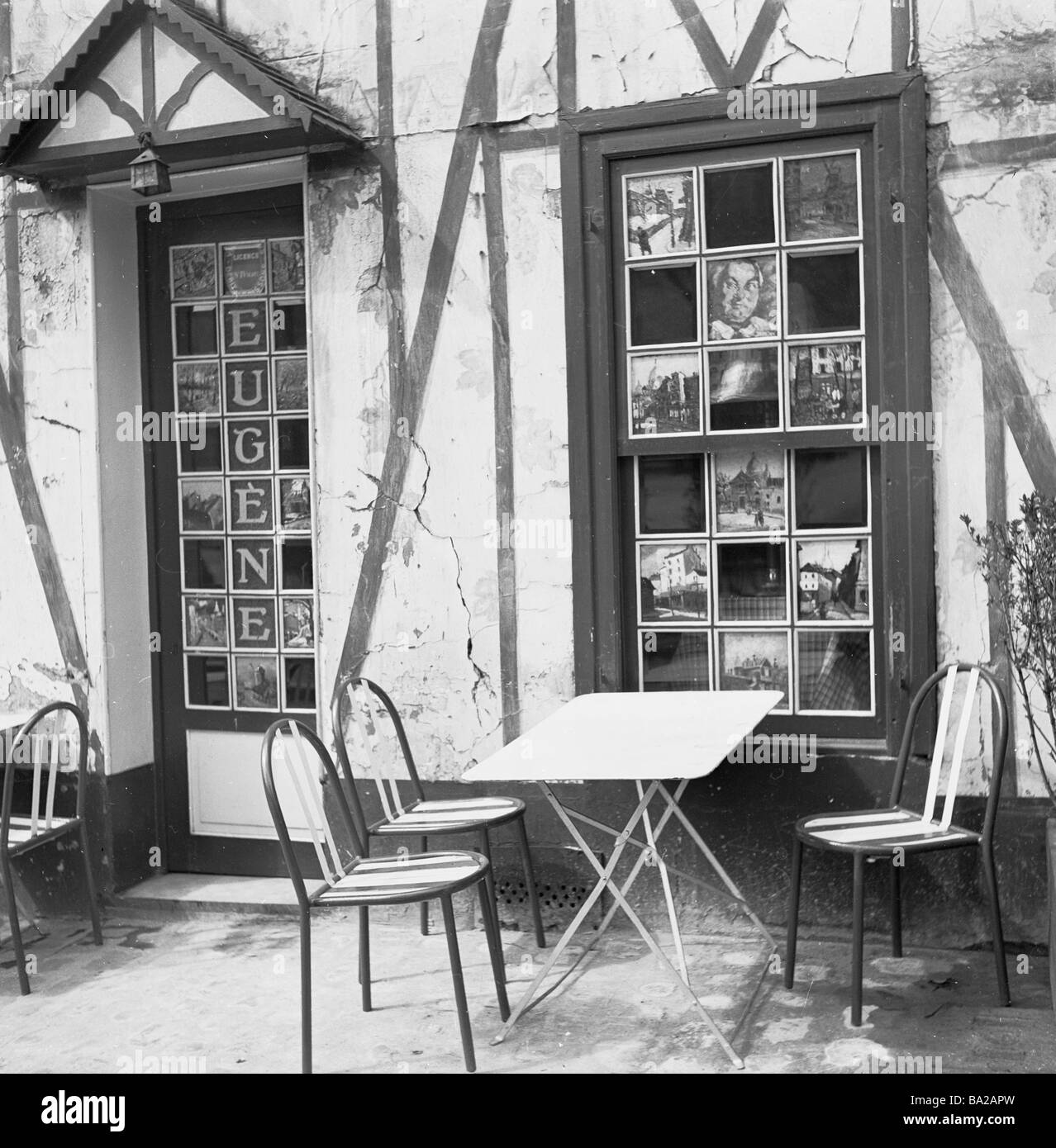 1950, Außen, Cafe Eugene, Place du Tertre, Montmartre, berühmt für seine Künstler auf der Straße und zeigt Gemälde in Fensterscheiben und Eingang, Paris Frankreich Stockfoto