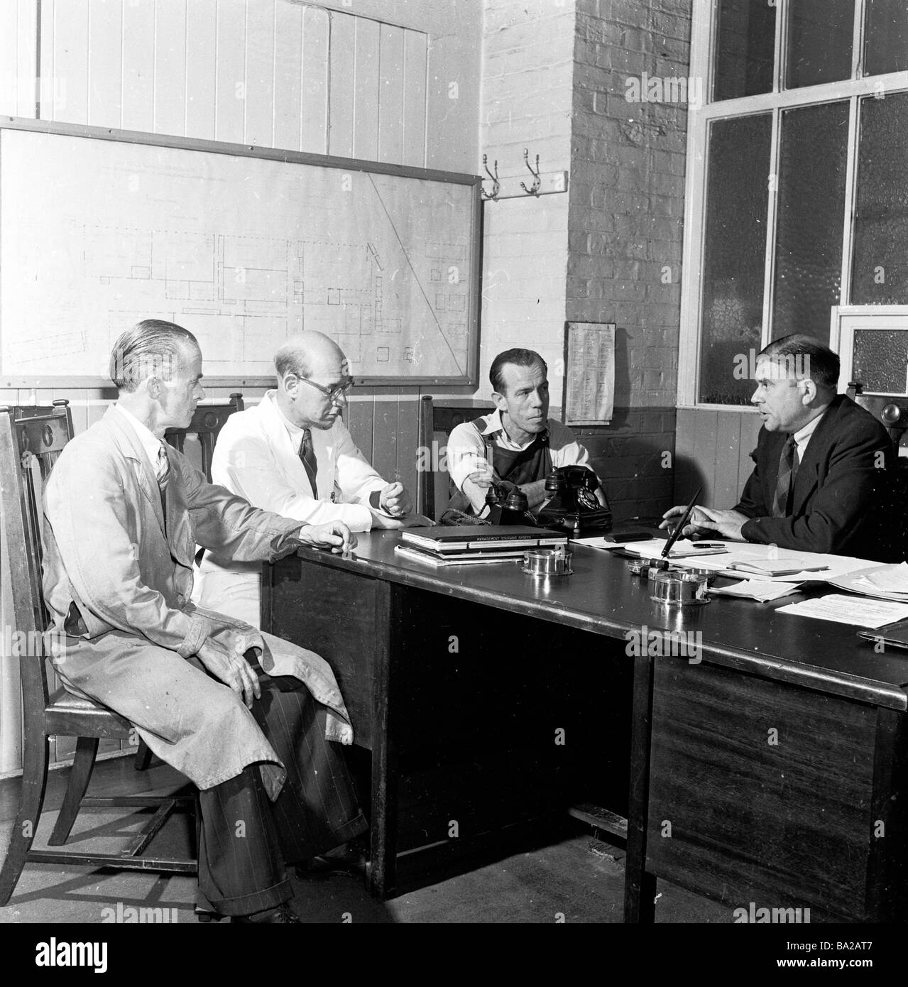 1950s, ein Treffen um einen Büroschalter, von Werksleiter, Vorarbeiter und Arbeitnehmervertreter, bei der Glacier Metal Company, Alperton, England, Großbritannien. Stockfoto