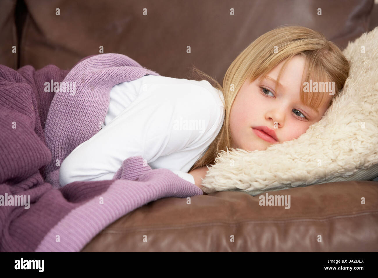 Junges Mädchen unwohl auf Sofa Stockfoto