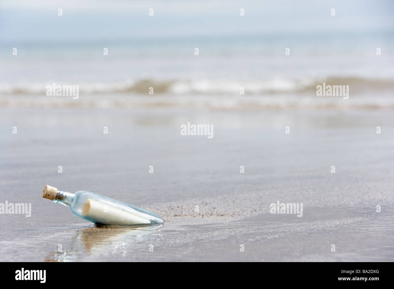 Message In A Bottle vergraben im Sand am Strand Stockfoto