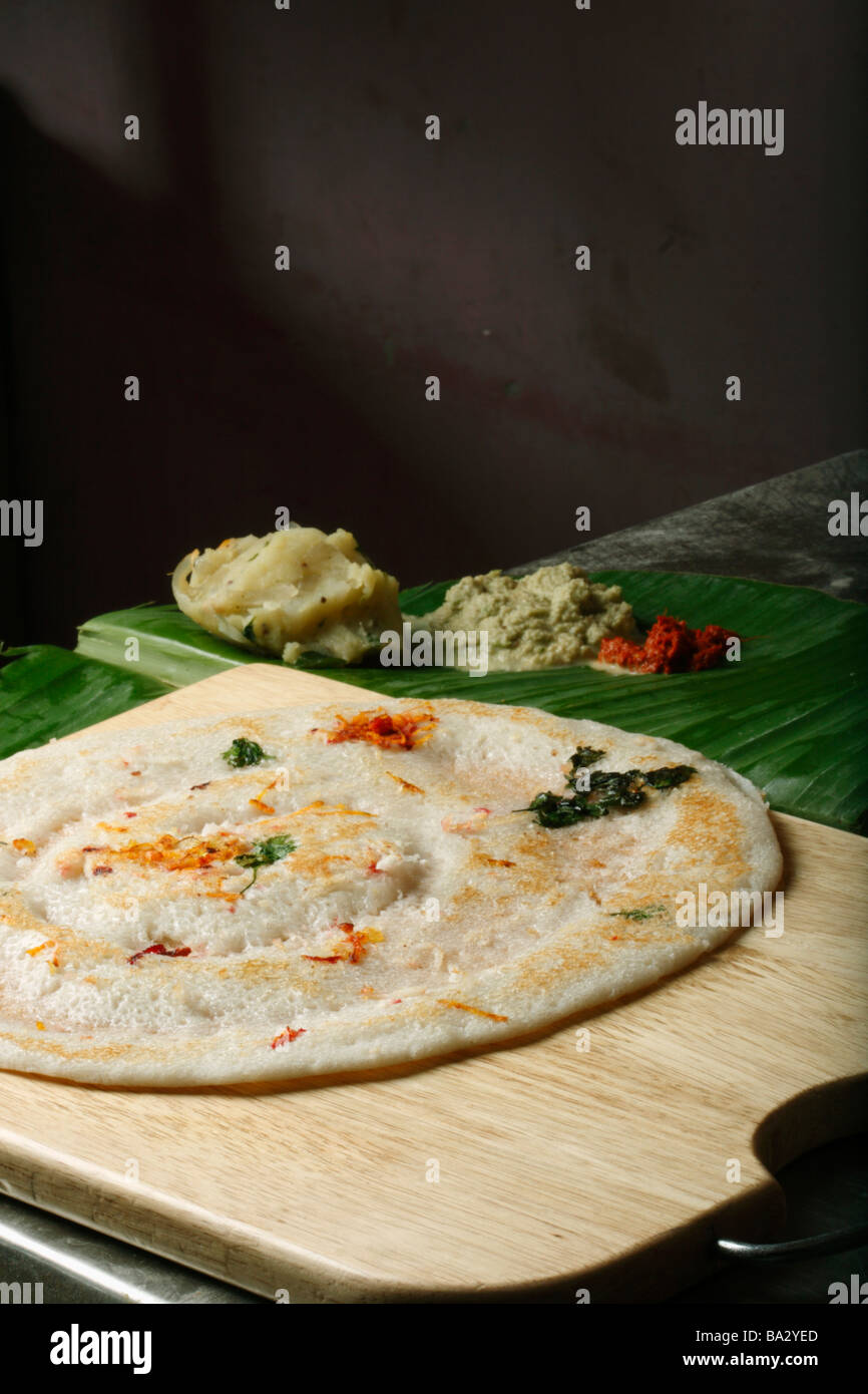 Uttapam ist ein Dosa-wie Pfannkuchen, der durch das Kochen Zutaten in einem Teig gemacht wird Stockfoto