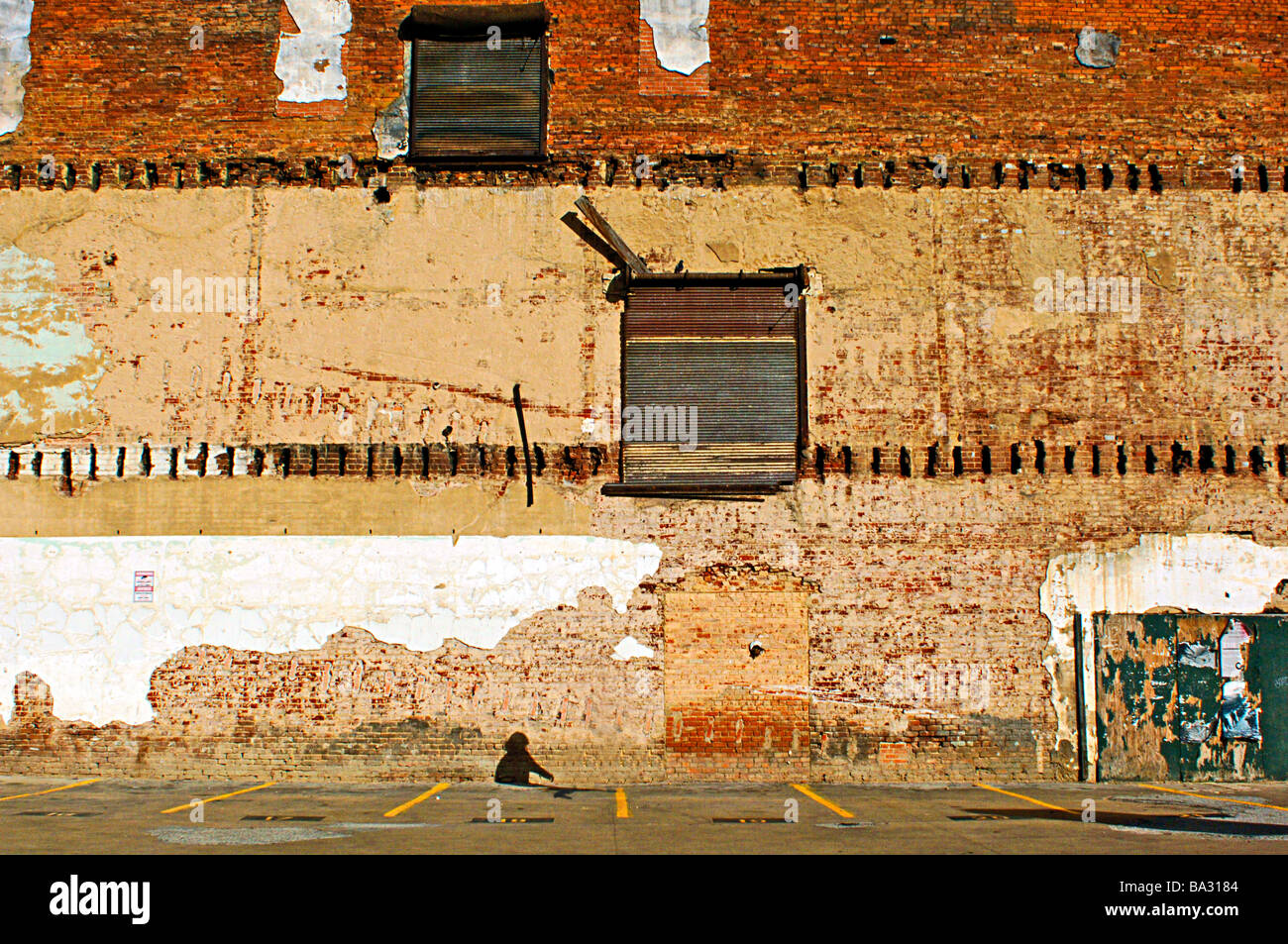 Schatten der Dame zu Fuß entlang der Kante eines verlassenen Gebäudes Stockfoto
