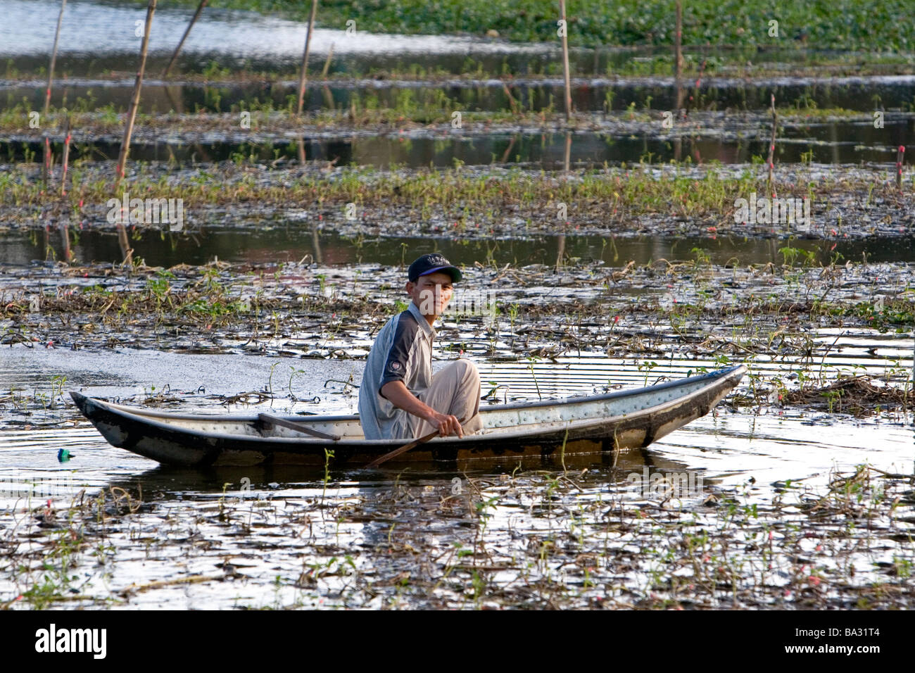 Vietnamesische Mann in einem Boot neigt dazu, einen Fischteich in Hue, Vietnam Stockfoto