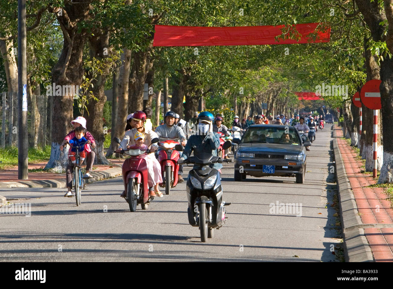 Menschen fahren Motorräder entlang der kaiserlichen Zitadelle von Hue, Vietnam Stockfoto
