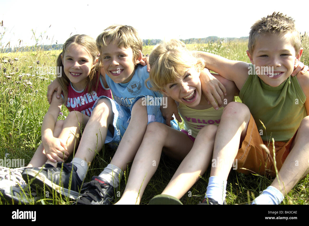 Kinder Wiese Sit Gruppenbild Serie Menschen Mädchen Jungen Freunden Arm In Arm Blick Kamera