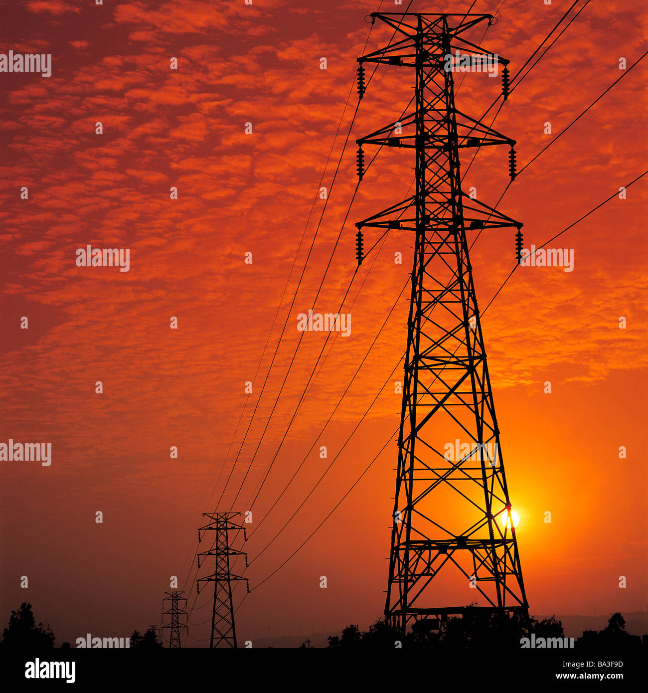 Pylon mit Stromleitungen gegen rötliche Himmelsblick niedrigen Winkel Stockfoto