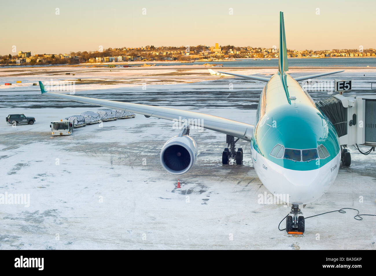Vordere erhöhte Ansicht von Passagierflugzeug geparkt auf der Piste mit Schnee während laden entladen. Stockfoto