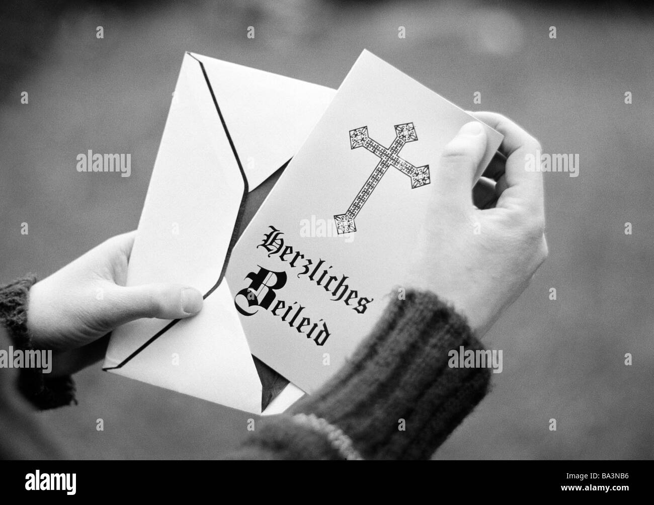 70er Jahre, schwarz / weiß Foto, Menschen, Tod, Trauer, Hände öffnen einen Umschlag mit einem Kondolenzschreiben Karte, Sympathie, aufrichtigen Mitgefühls Stockfoto
