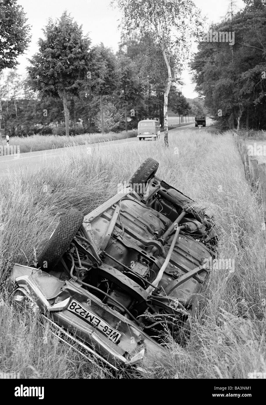 70er Jahre, schwarz / weiß Foto, Verkehr, Autounfall auf einer Landstraße, PKW Auto liegt in den Straßengraben zerstört Auto, Totalschaden, Kreis Borken, Münsterland, Nordrhein-Westfalen Stockfoto