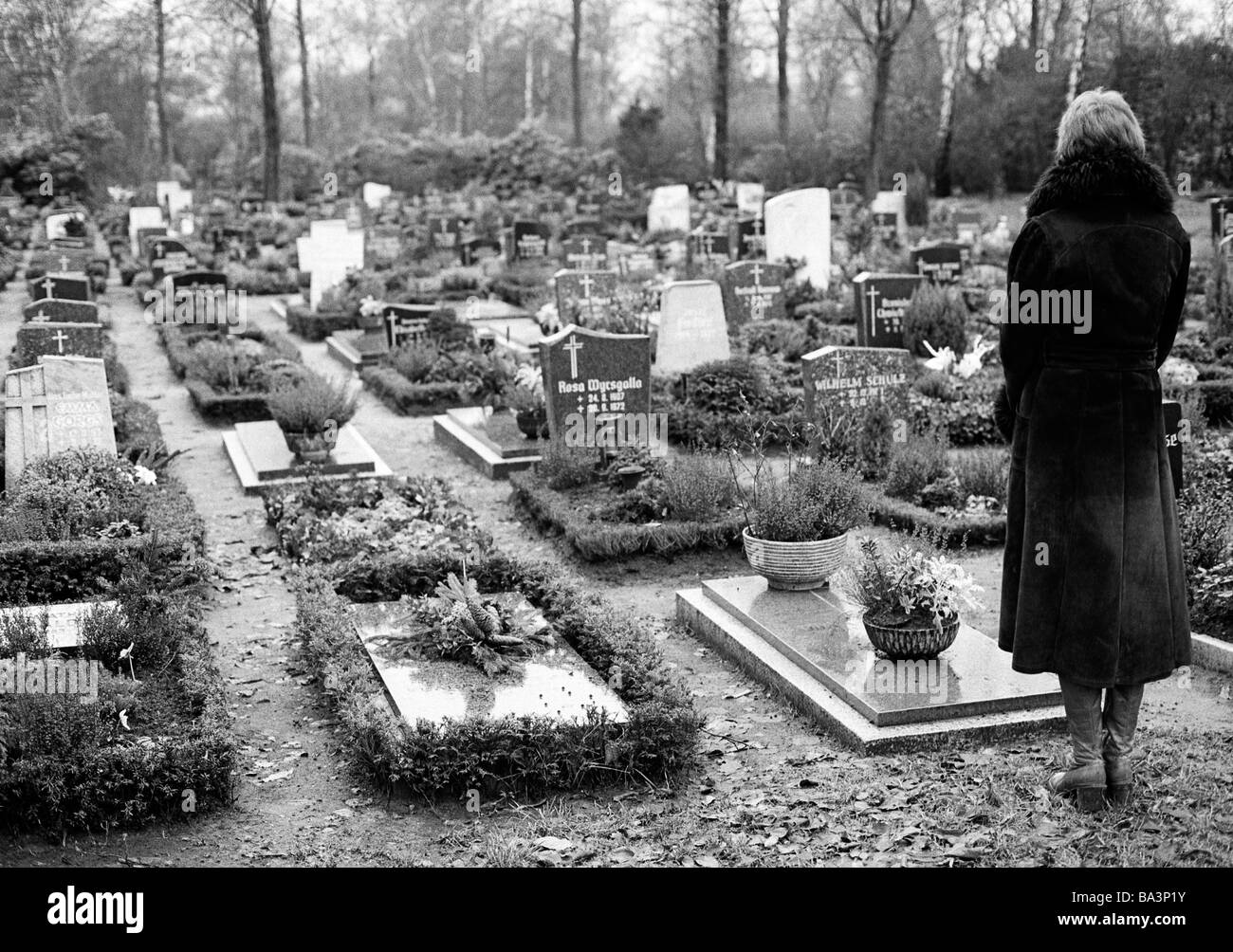 Der siebziger Jahre, schwarz / weiß Foto, Menschen, Tod, Trauer, Friedhof, junge Frau steht auf einem Grab, im Alter von 25 bis 30 Jahren, Monika Stockfoto