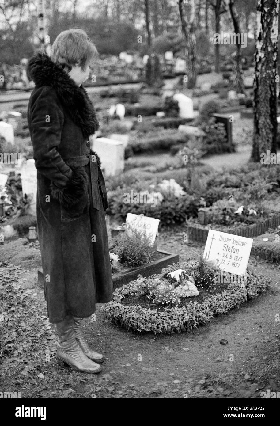 70er Jahre, schwarz / weiß Foto, Menschen, Tod, Trauer, Friedhof, junge Frau steht auf einem Grab, Grab eines Kindes im Alter von 25 bis 30 Jahre, Monika Stockfoto