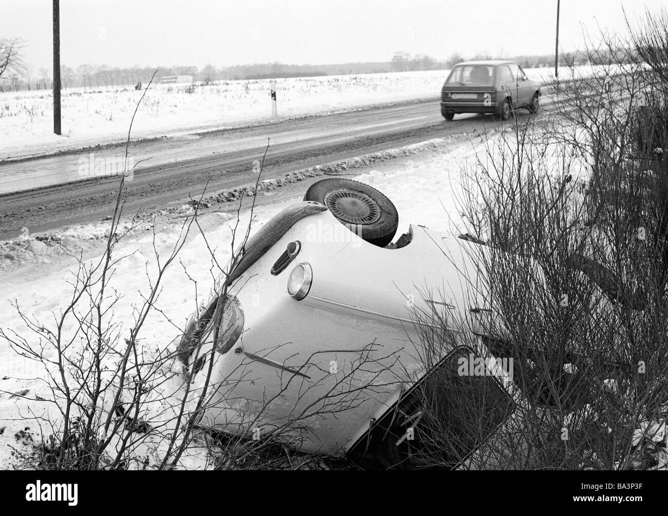 70er Jahre, schwarz / weiß Foto, Verkehr, Autounfall auf einer Landstraße, PKW Auto liegt in den Straßengraben, D-Bottrop, D-Bottrop-Kirchhellen, Ruhrgebiet, Nordrhein-Westfalen Stockfoto