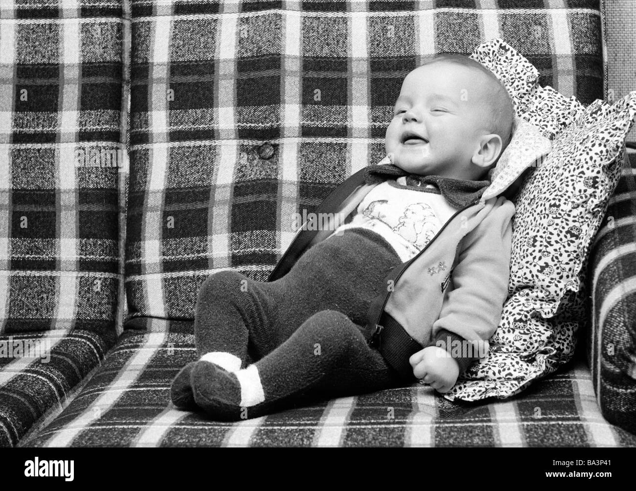 70er Jahre, schwarz / weiß Foto, Menschen, Kinder, Baby liegt auf einer Couch, lachen, im Alter von 6 bis 12 Monaten, im Alter von 1 Jahr, Andreas Stockfoto
