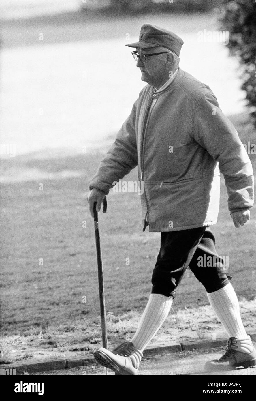 70er Jahre, schwarz / weiß Foto, Menschen, älterer Mann zu Fuß mit einem Gehstock, Freizeitsport, Gesundheit, im Alter von 70 bis 80 Jahre Stockfoto