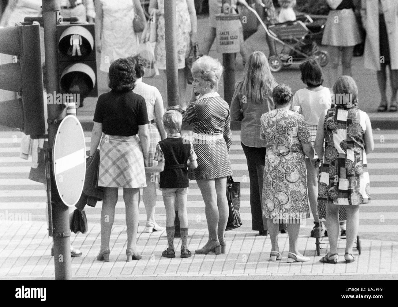 70er Jahre, schwarz / weiß Foto, Menschen auf Einkaufsbummel, mehrere Frauen und einen jungen warten an einer Ampel, Zebrastreifen Stockfoto