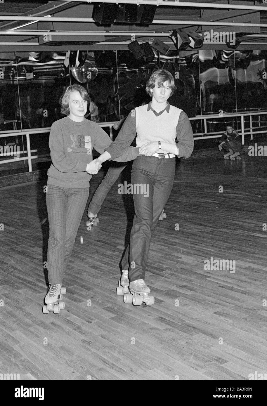 Achtziger Jahre, schwarz / weiß Foto, Menschen, junges Paar auf Rollerblades in einer Sporthalle, Hosen, Pulli, im Alter von 15 bis 18 Jahre Stockfoto