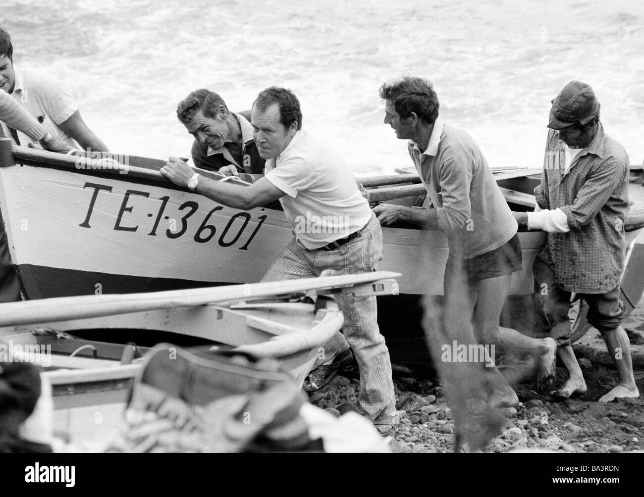 Achtziger Jahre, schwarz / weiß Foto, einige Fischer in der Fischerei-Hafen von Puerto De La Cruz-Pull ein Fischerboot an Land, im Alter von 40 bis 60 Jahre, Teneriffa, Kanaren, Kanarische Inseln, Spanien Stockfoto