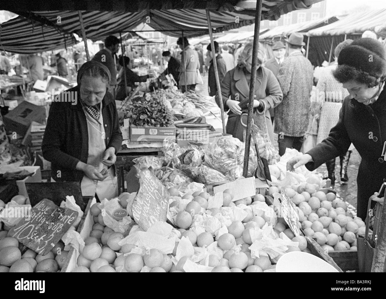 70er Jahre, schwarz / weiß Foto, Menschen, Wochenmarkt, Marktstand mit Obst und Gemüse, Verkäuferin, Vermarkter, im Alter von 70 bis 80 Jahre, shopping Hausfrauen, im Alter von 40 bis 60 Jahre Stockfoto