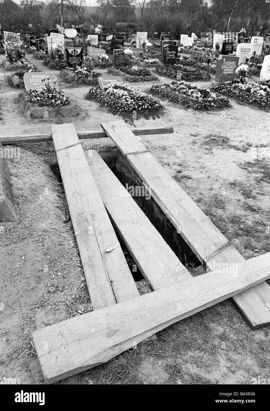 70er Jahre, schwarz / weiß Foto, Menschen, Tod, Trauer, Friedhof, Bestattung, Grab, Planken über einem offenen Grab Stockfoto