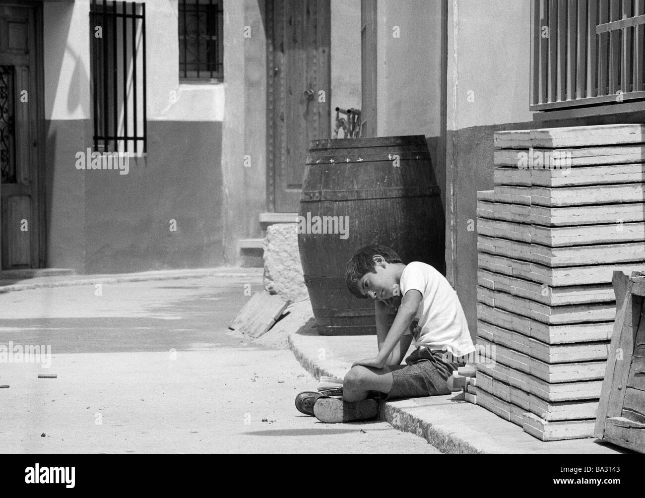 Der siebziger Jahre, schwarz / weiß Foto, Menschen, Kinder, kleiner Junge sitzt am Straßenrand, Traurigkeit, Straßenkind, im Alter von 9 bis 12 Jahre, Spanien, Valencia Stockfoto