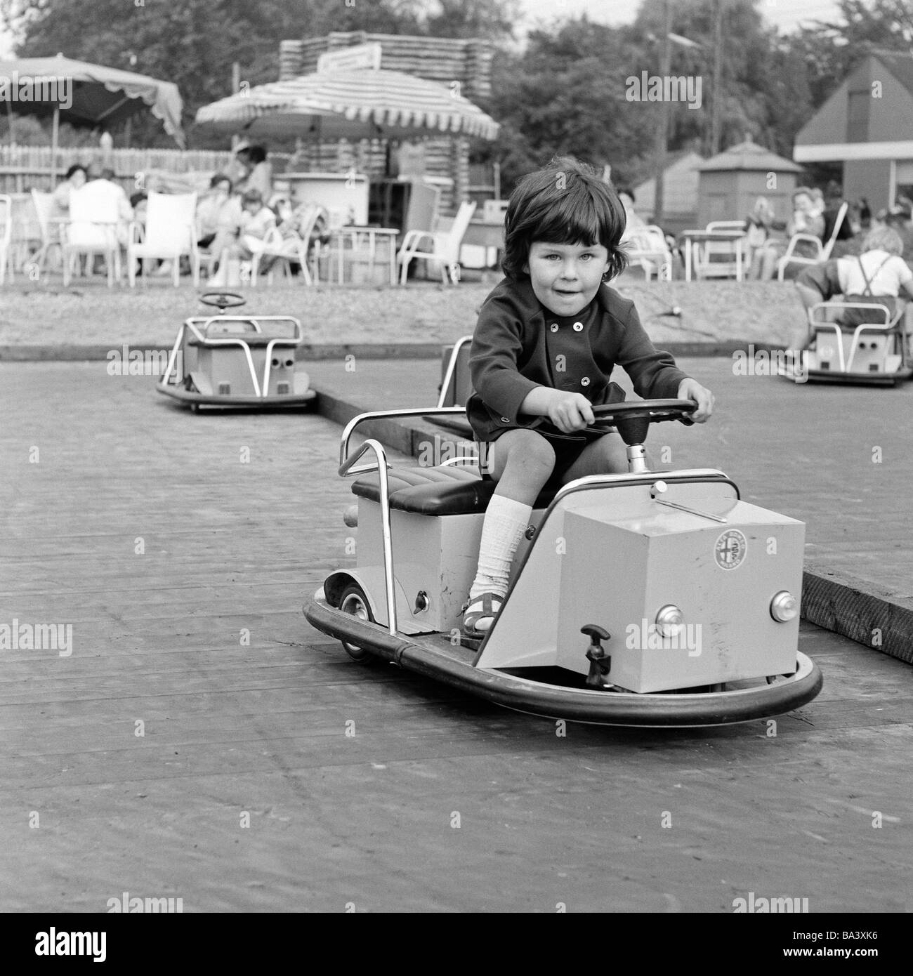 70er Jahre, schwarz / weiß Foto, Menschen, Kinder, Mädchen-Laufwerke mit einem Modellauto, Dodgem Auto, Kinderspielplatz, im Alter von 3 bis 4 Jahre Stockfoto