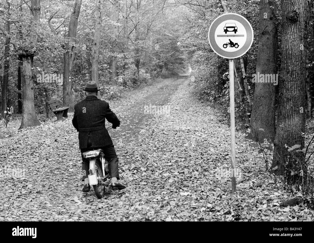 70er Jahre, schwarz / weiß Foto, Herbst, Wald, Wald, Straße, Verbotszeichen, kein Eintrag für Autos und Motorräder, dennoch ein älterer Mann auf einem Moped durchläuft, im Alter von 60 bis 70 Jahre, D-Bottrop, D-Bottrop-Kirchhellen, Grafenwald, Ruhrgebiet, Nordrhein-Westfalen Stockfoto
