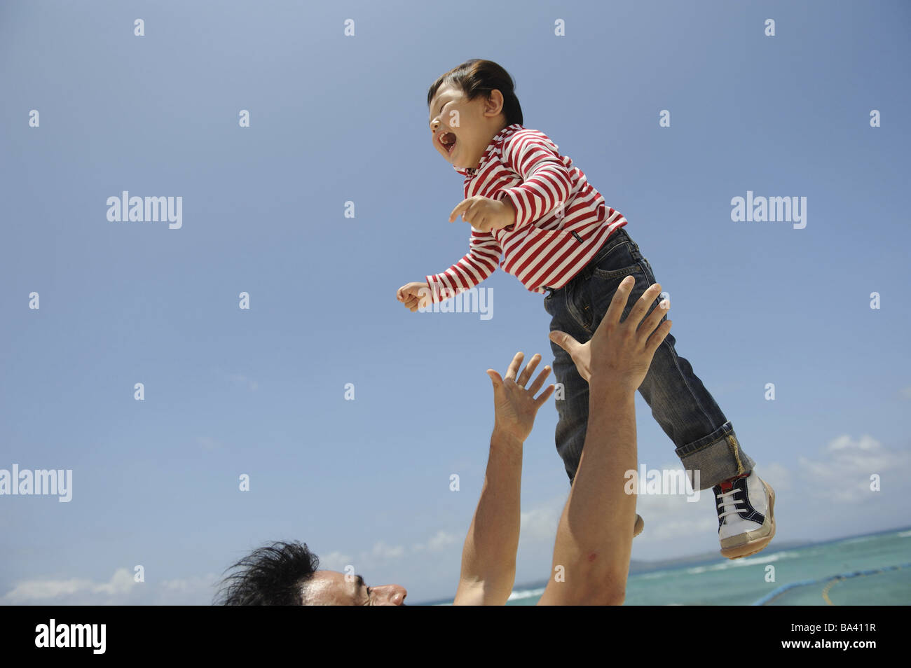 Vater heben Kind in Luft Stockfoto