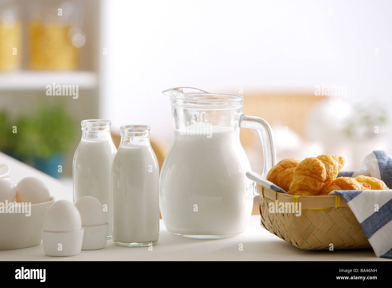 Milch, Eiern und Brot am Esstisch Stockfoto