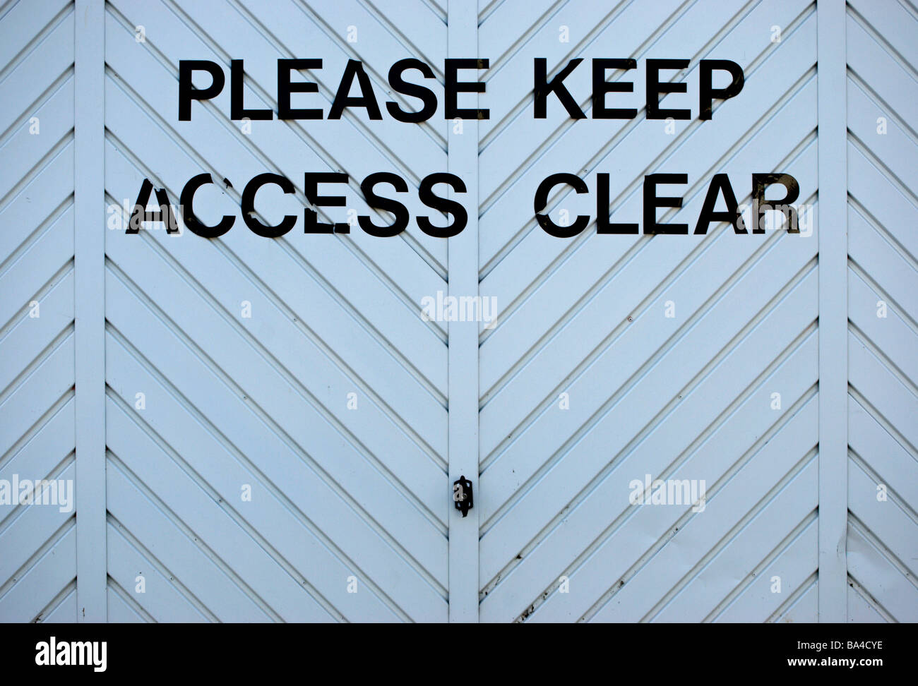 Bitte halten Sie Zugang klar geschrieben auf einem Zickzack-Muster-Garagentor Stockfoto
