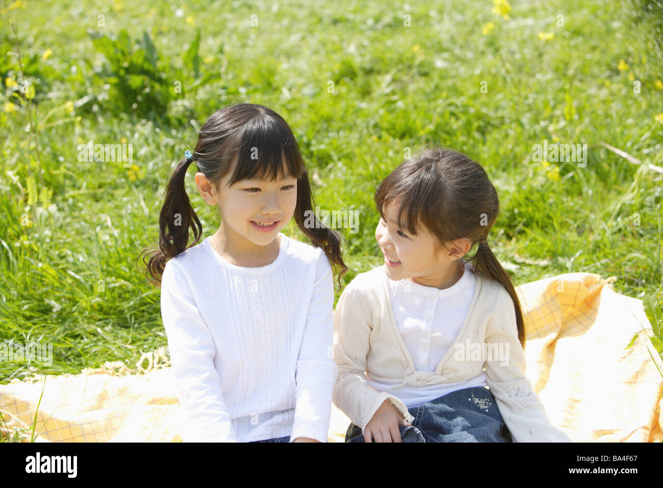 Japanische Mädchen sitzen in einem Garten Stockfoto