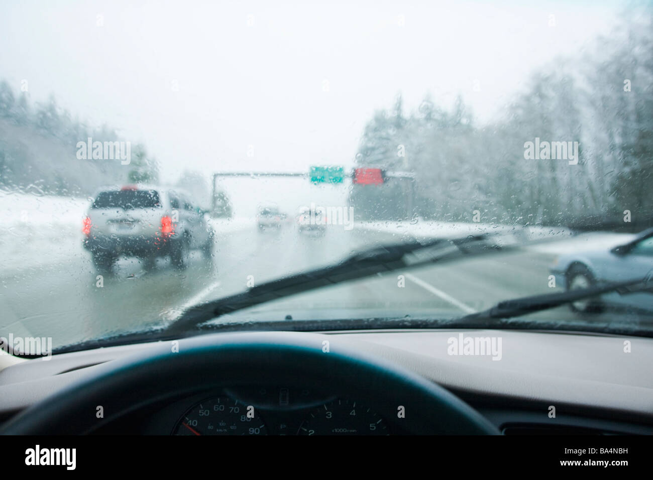 Autofahren in Stoßstange an Stoßstange Verkehr durch die Berge in einem Regen-Schnee-Sturm Stockfoto