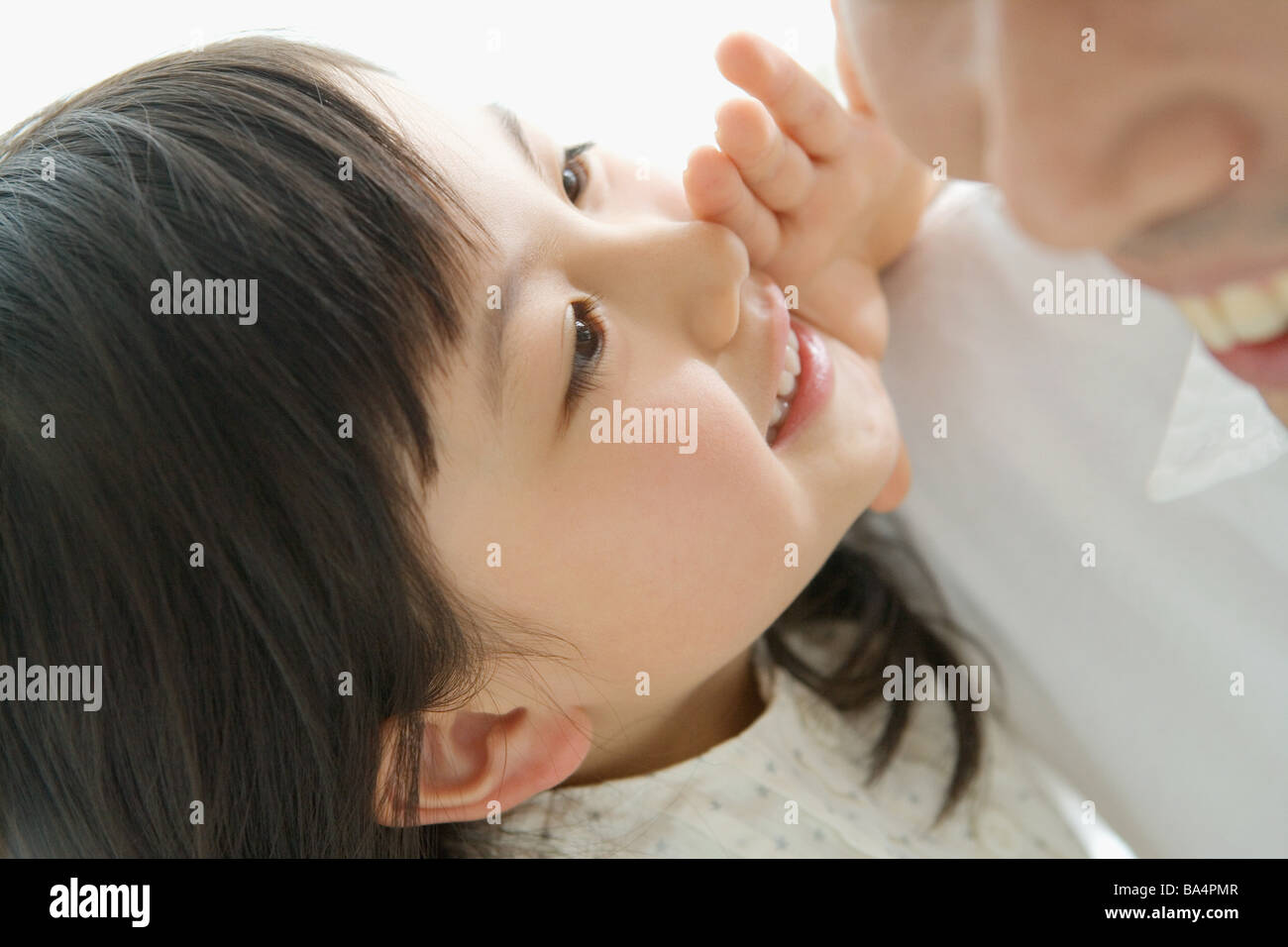Tochter in ihren Vater Ohren flüstern Stockfoto