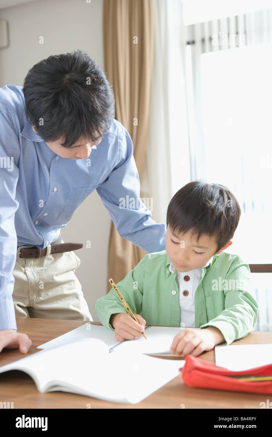 Japanische junge Hausaufgaben mit seinem Vater Stockfoto