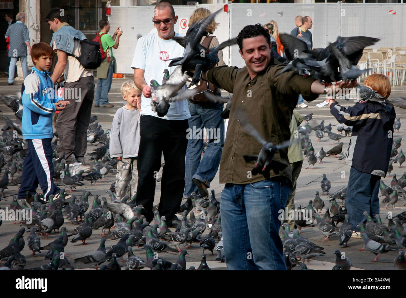 Mann spielt mit den Tauben in St. Markus Platz Venedig Stockfoto