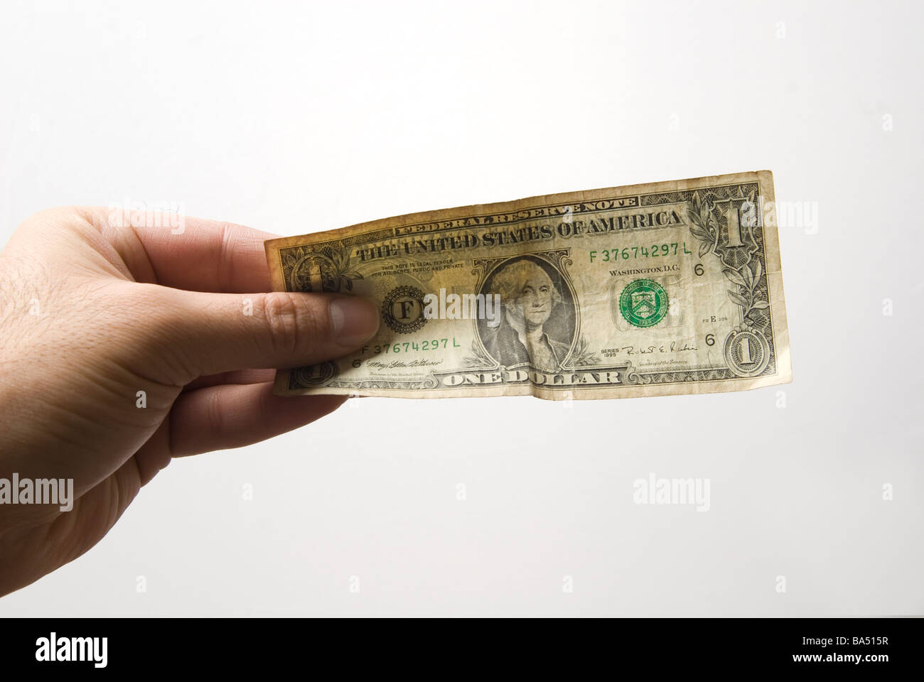 Hand, die ein-Dollar-Banknote vor einem weißen Hintergrund Stockfoto