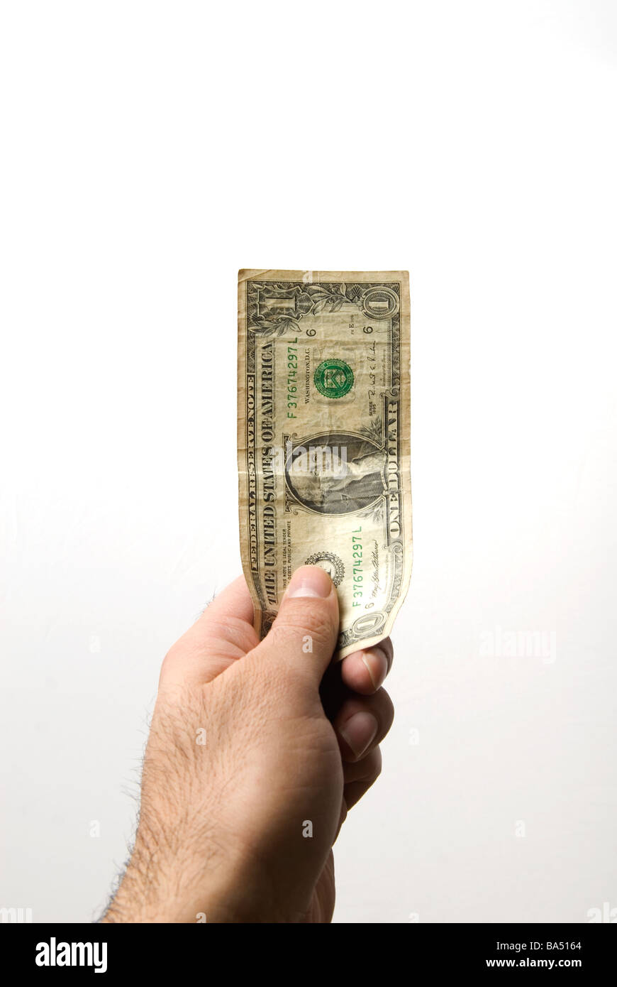 Hand, die ein-Dollar-Banknote vor einem weißen Hintergrund Stockfoto