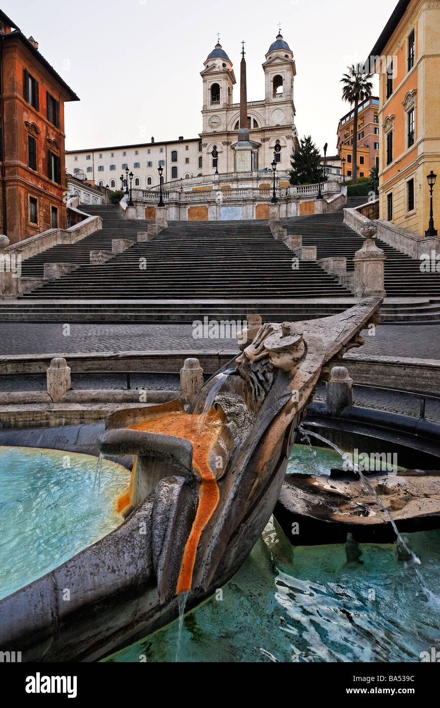 Detail der Fontana della Barcaccia in Piazza di Spagna mit der spanischen Treppe und der Kirche der Trinità dei Monti über Stockfoto