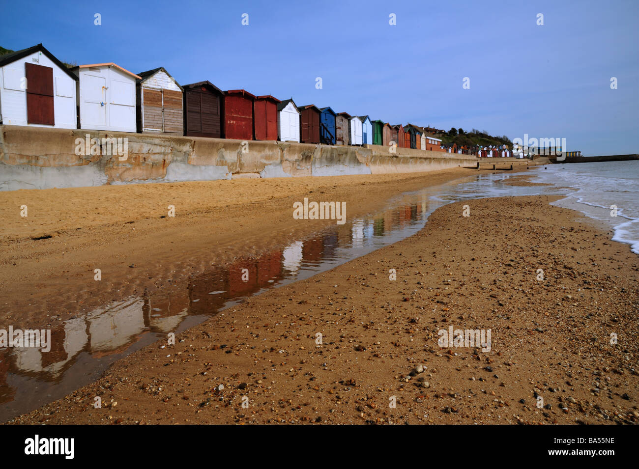 WALTON-ON-THE NAZE, ESSEX, Großbritannien - 05. APRIL 2009: Beach Huts On with Reflection in Water on the Beach Stockfoto