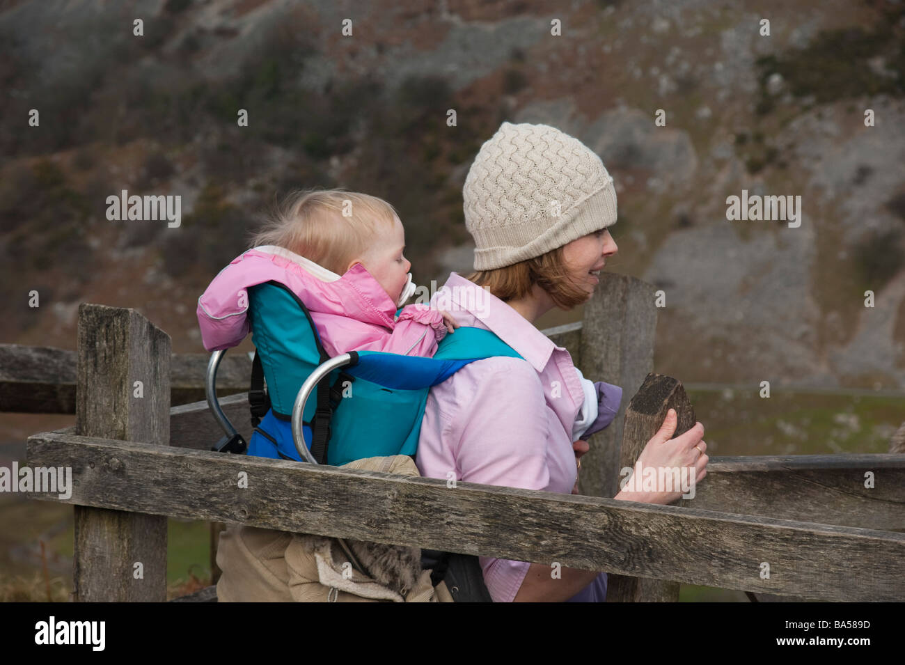 Wales - Mutter gehen mit 18 Monate altes Baby in Rucksack Stockfoto