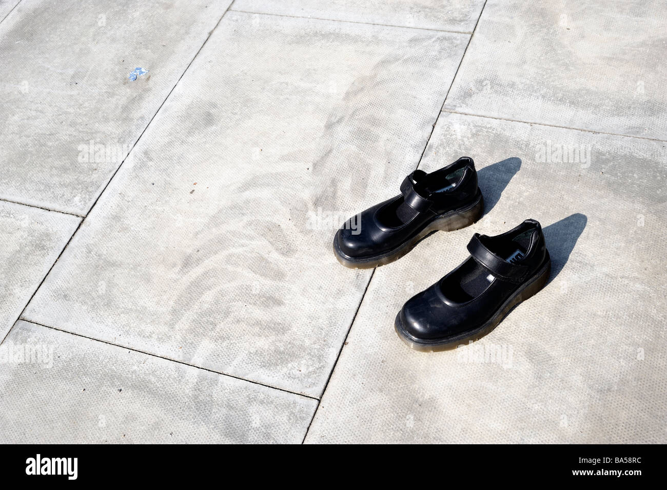Schuhe auf Beton Pflastersteine neben Reifen verfolgen Stockfoto