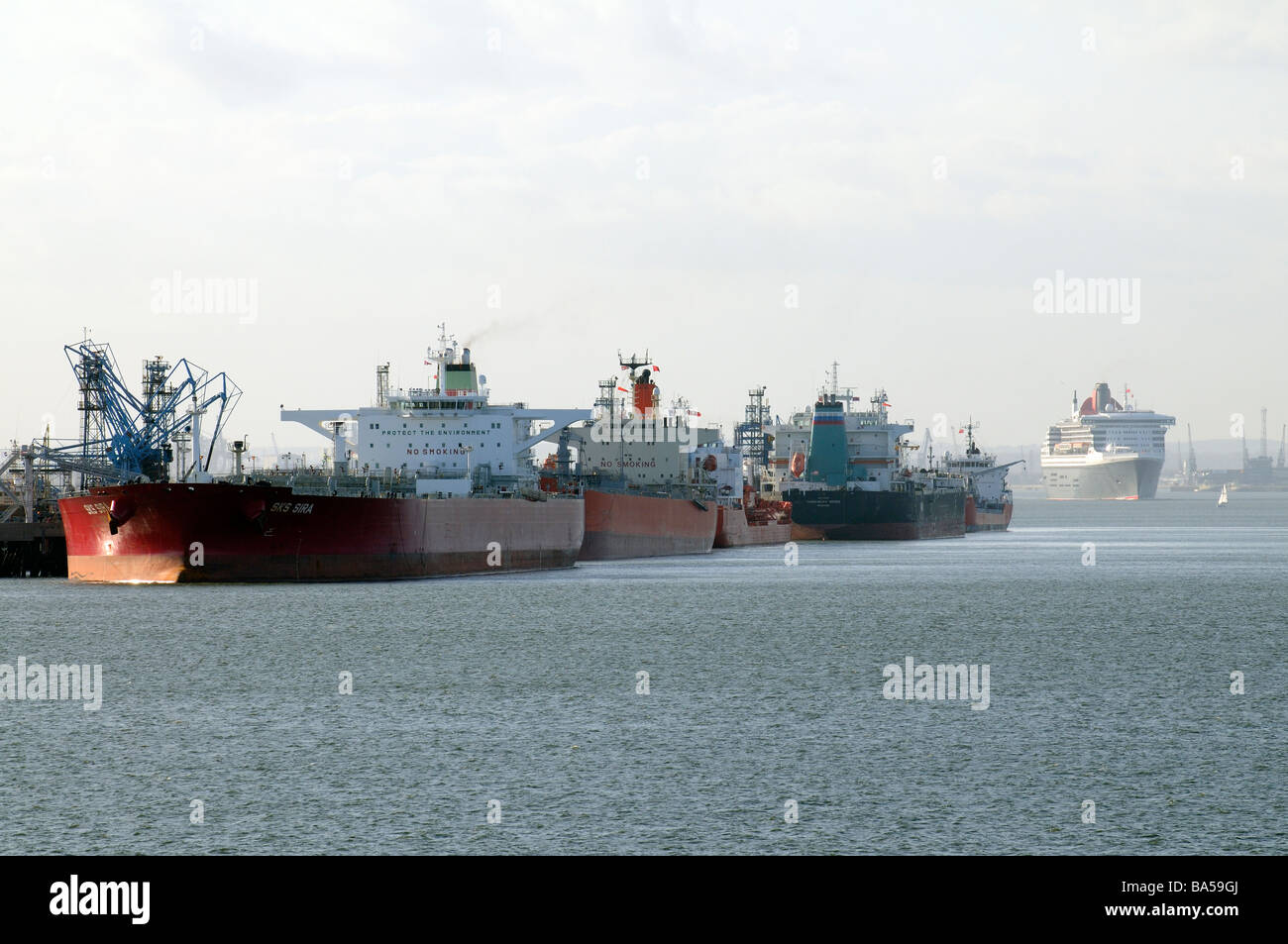 Öl- und Chemikalientankern festgemacht in Fawley Raffinerie am Southampton Water das Kreuzfahrtschiff, die, das Queen Mary 2 im Gange ist Stockfoto