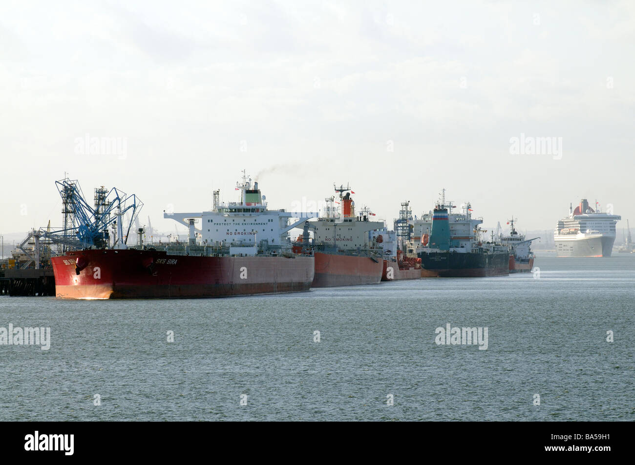 Öl- und Chemikalientankern festgemacht in Fawley Raffinerie am Southampton Water das Kreuzfahrtschiff, die, dem Queen Mary 2 ist im Gange ausgehende aus Stockfoto